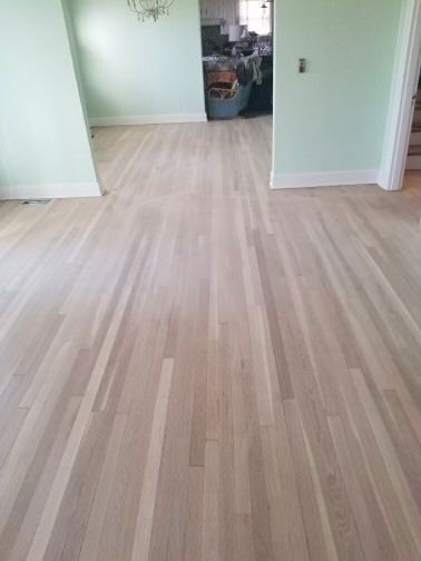 A living room with a wooden floor and green walls