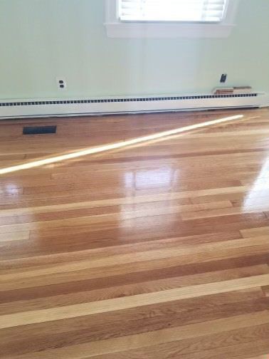 A living room with hardwood floors and a window.