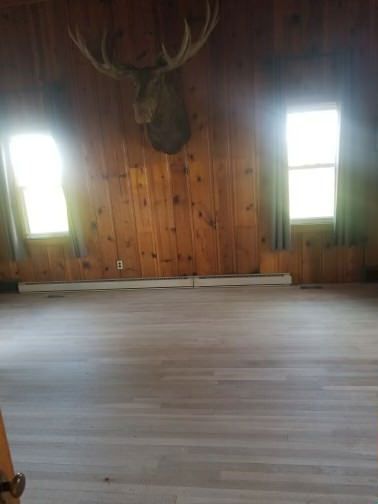 An empty room with a deer head hanging on the wall.