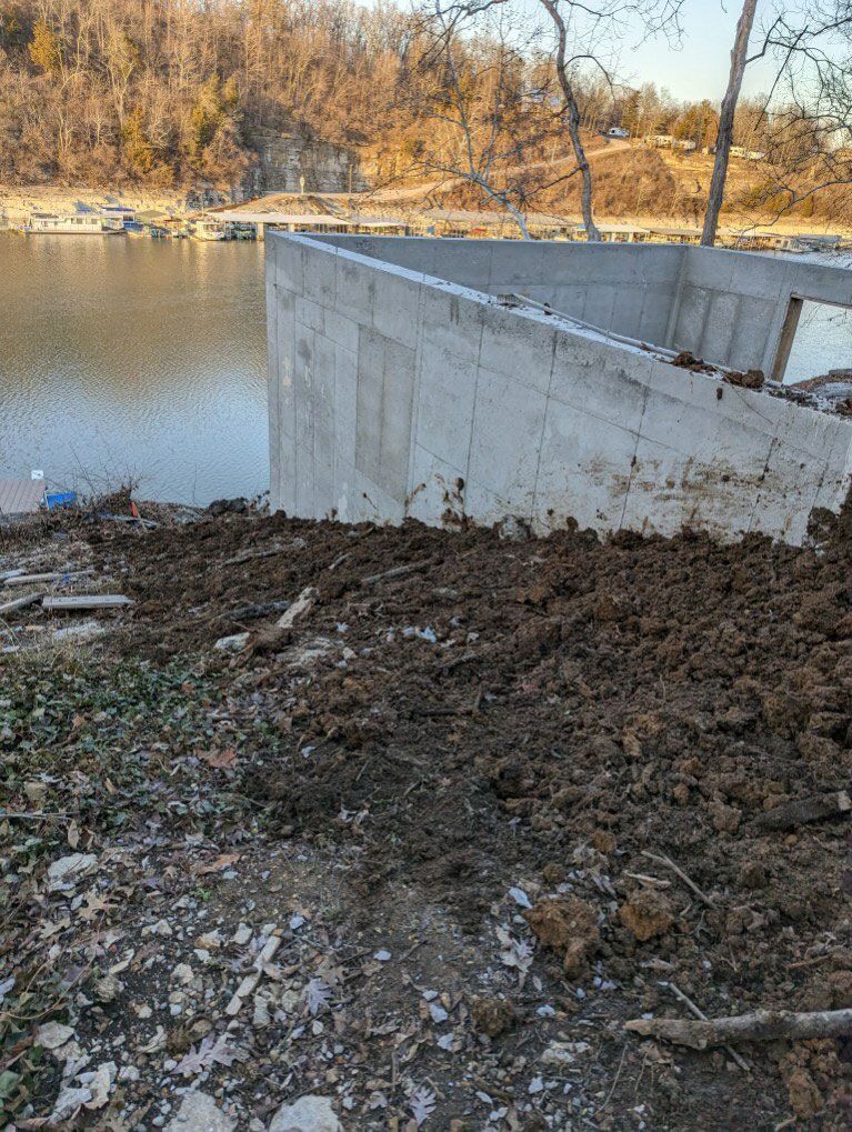 A large pile of dirt is sitting next to a body of water