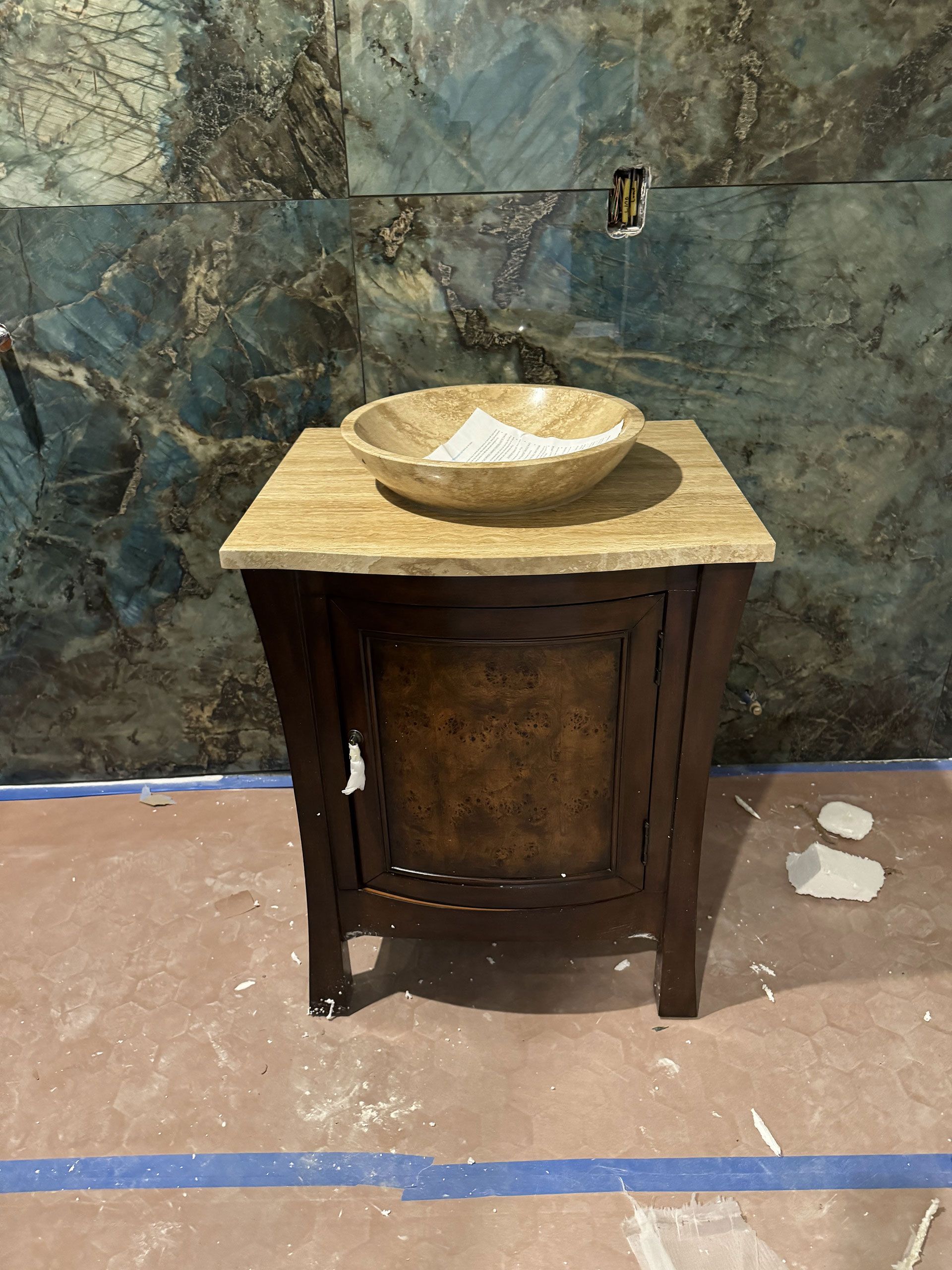 A bathroom sink is sitting on top of a wooden cabinet