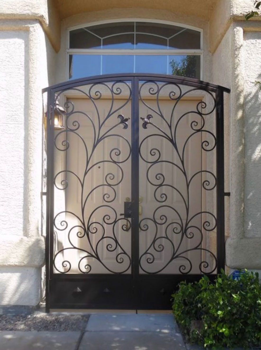 A wrought iron gate is in front of a house