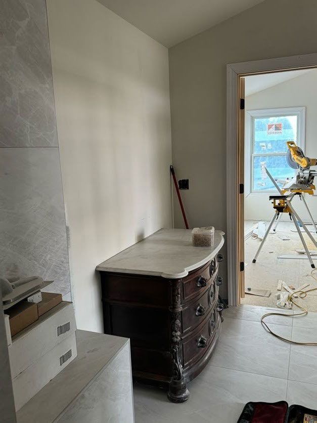 A dresser is sitting in a room next to a window