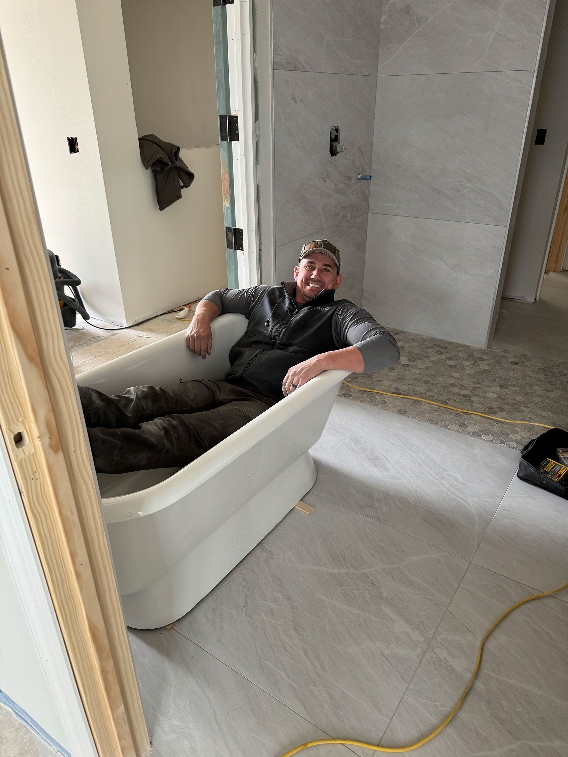 A man is laying in a bathtub in a bathroom
