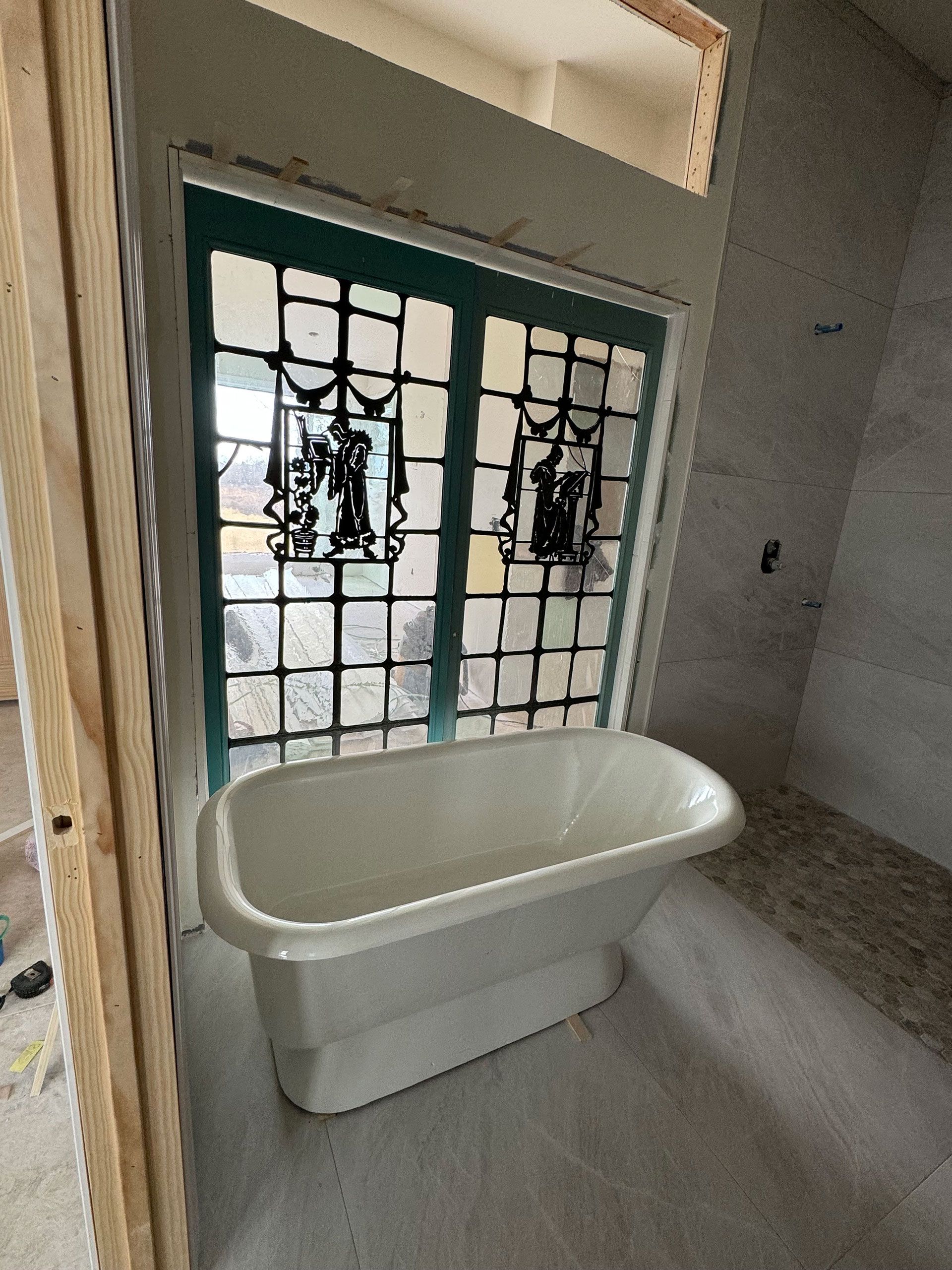 A bathroom with a bathtub and stained glass windows