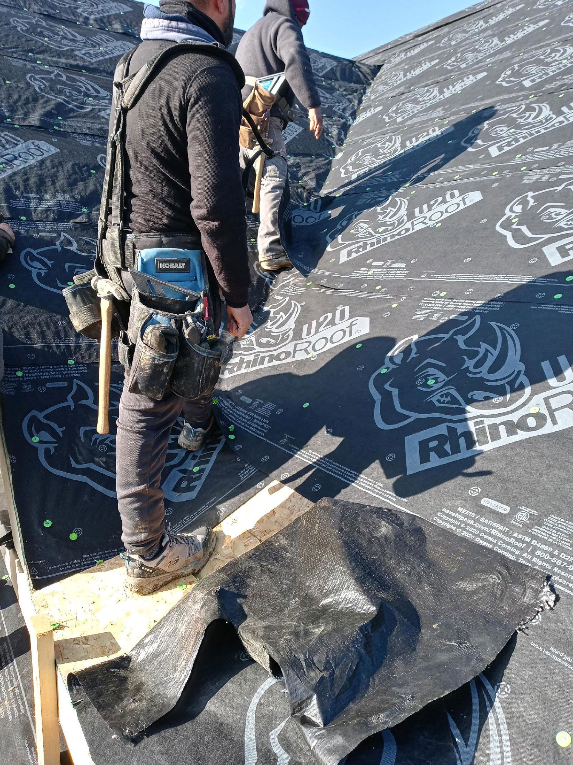 A group of men are working on a roof.