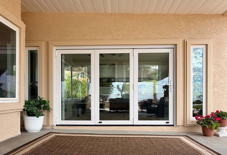 Patio with large sliding glass doors, potted plants, and a beige covered porch