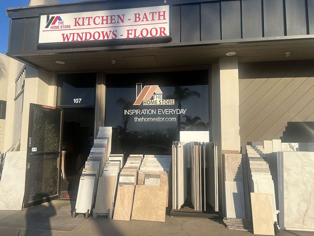 Storefront for kitchen and bath windows and flooring, with stacked tile and stone samples outside.