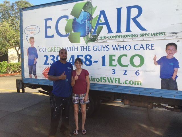 Three people stand in front of an ECOAIR service truck with a large company logo and phone number.