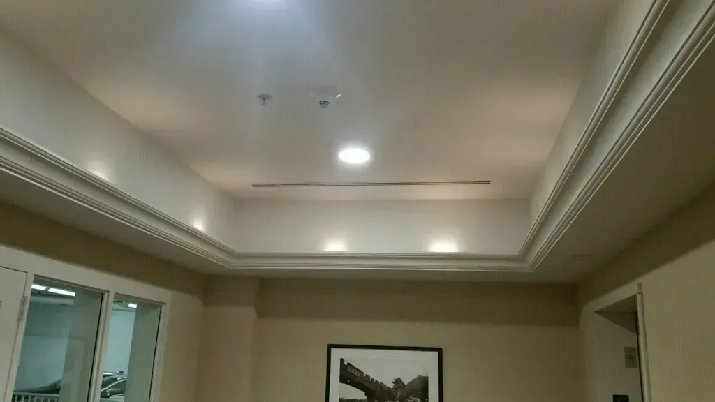 Ceiling with recessed lighting and decorative molding.