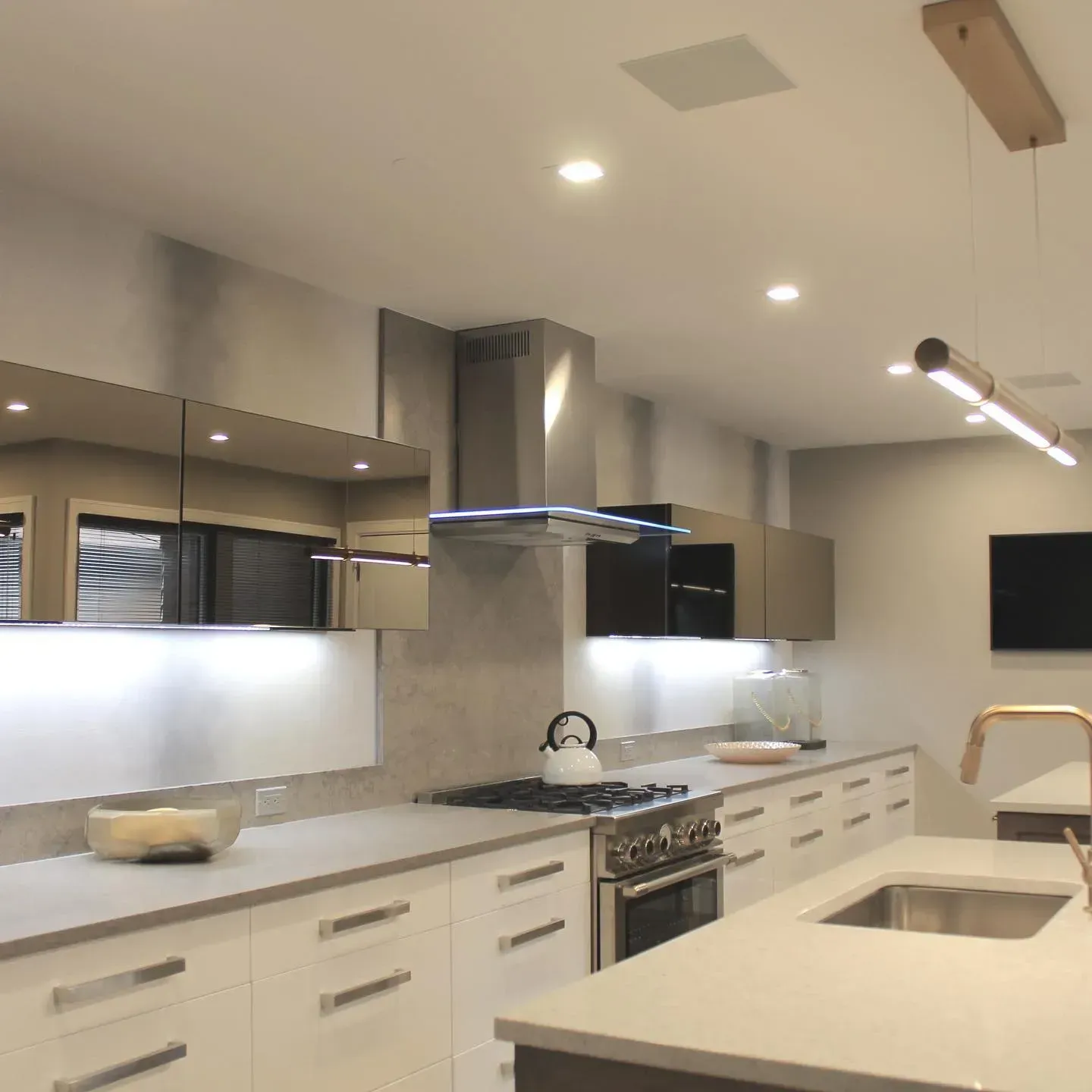 Modern kitchen with white cabinets, stainless steel appliances, and a gray countertop.