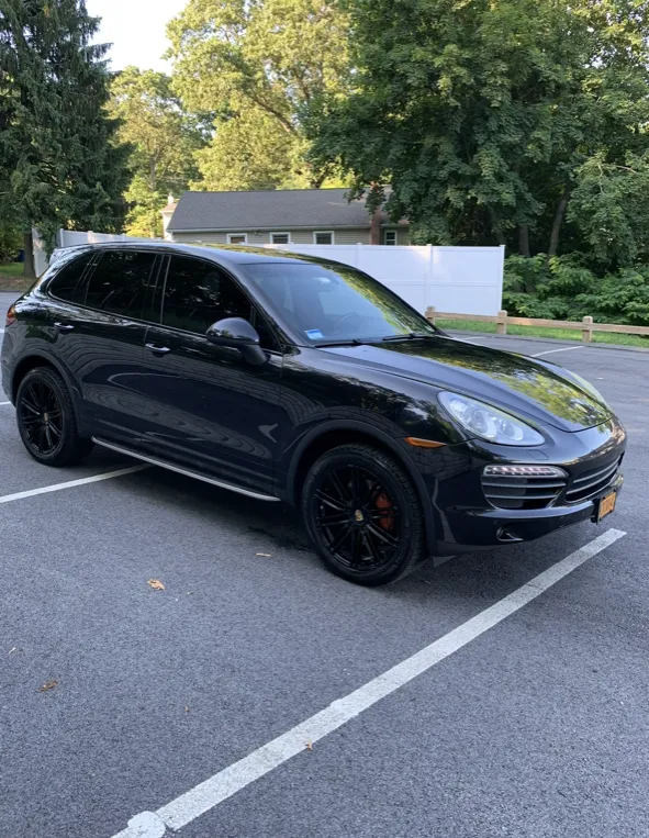 Black Porsche Cayenne SUV parked in a parking lot.