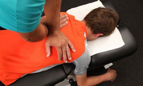 A Chiropractor treating a young boy