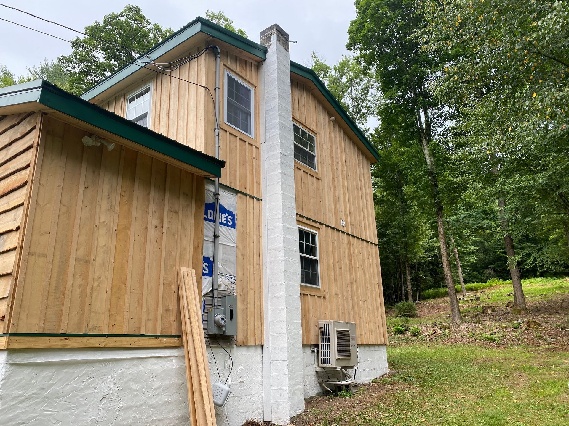Wooden house exterior with chimney, surrounded by trees.