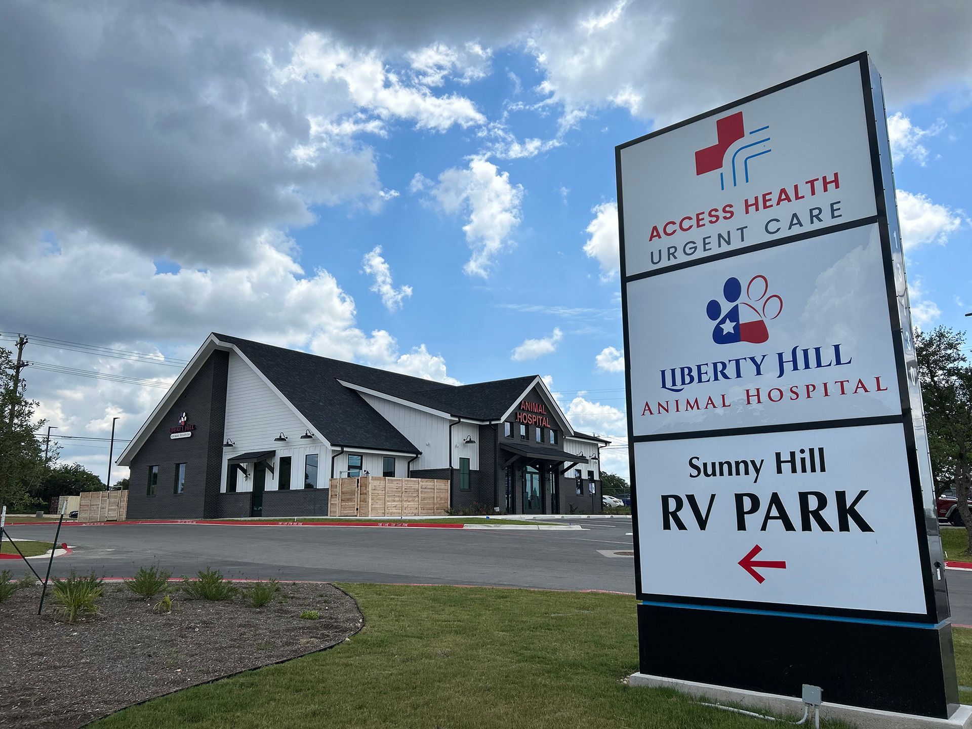 Exterior of Access Health Urgent Care and Liberty Hill Animal Hospital building with a sign for Sunny Hill RV Park.