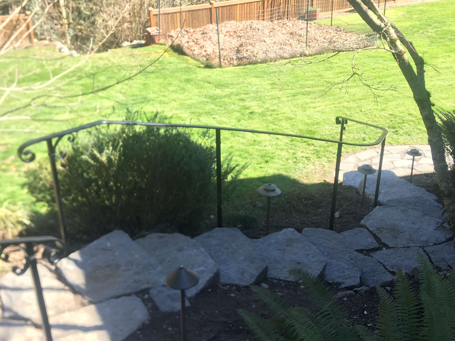 A set of stairs leading up to a lush green yard