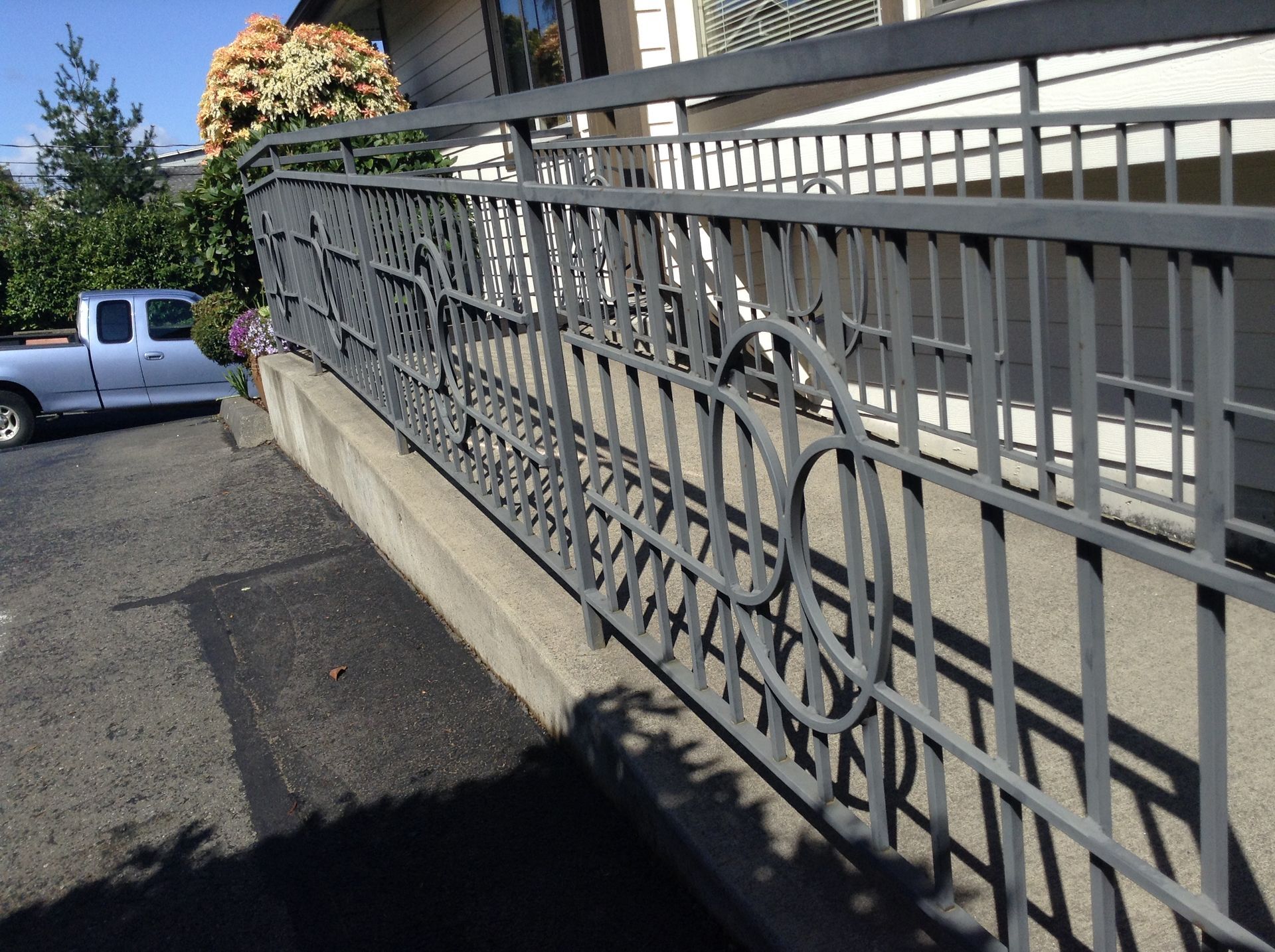 A white truck is parked behind a metal fence