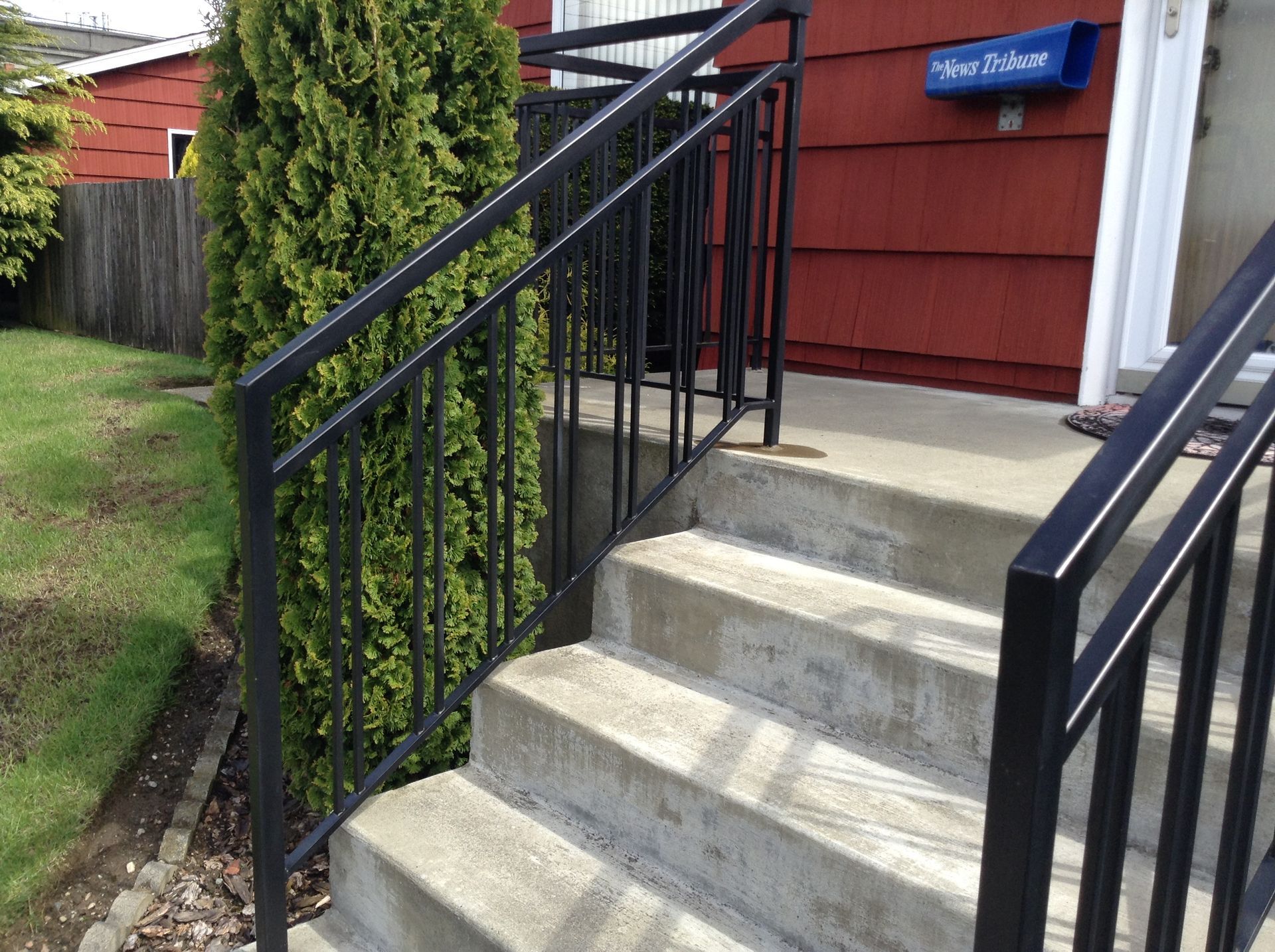 Stairs leading up to a red house with a blue mailbox