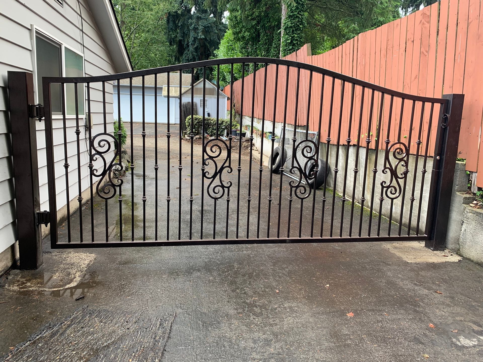 A wrought iron gate is sitting in front of a house