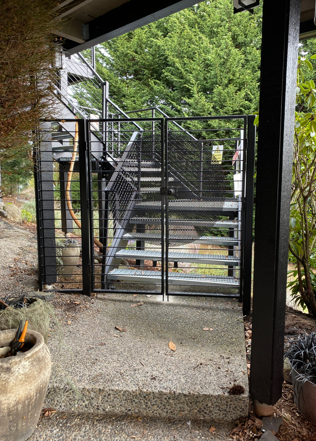 A black gate is leading to a set of stairs
