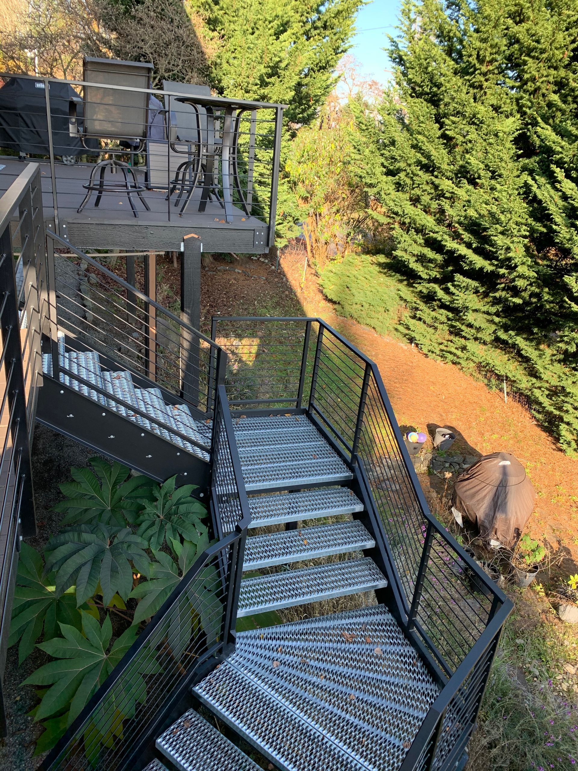 A set of stairs leading up to a deck surrounded by trees