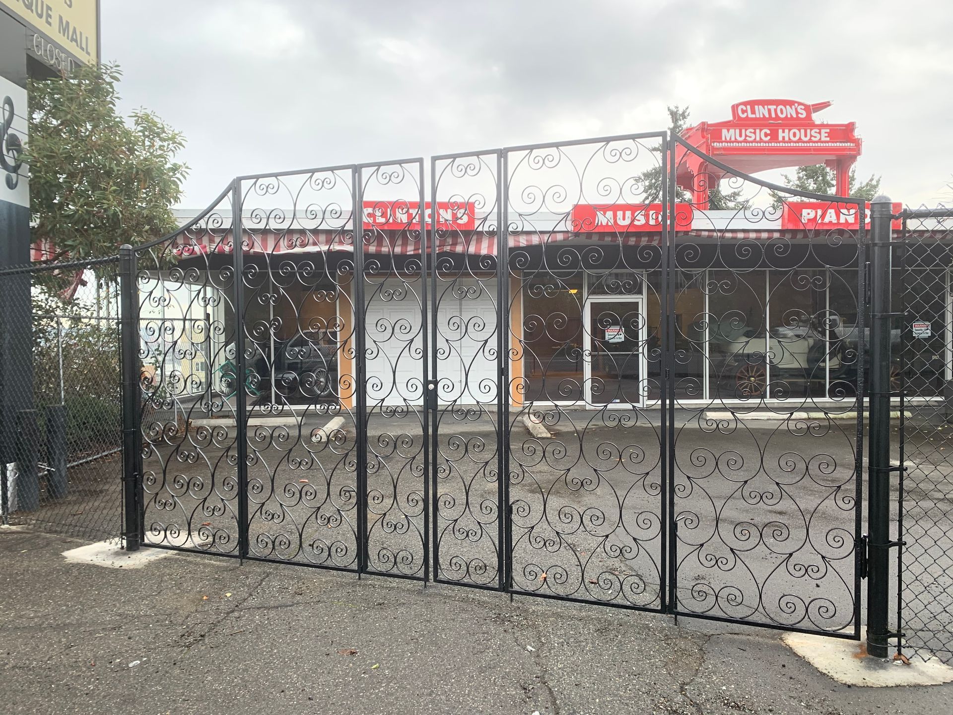 A wrought iron gate is sitting in the driveway of a house