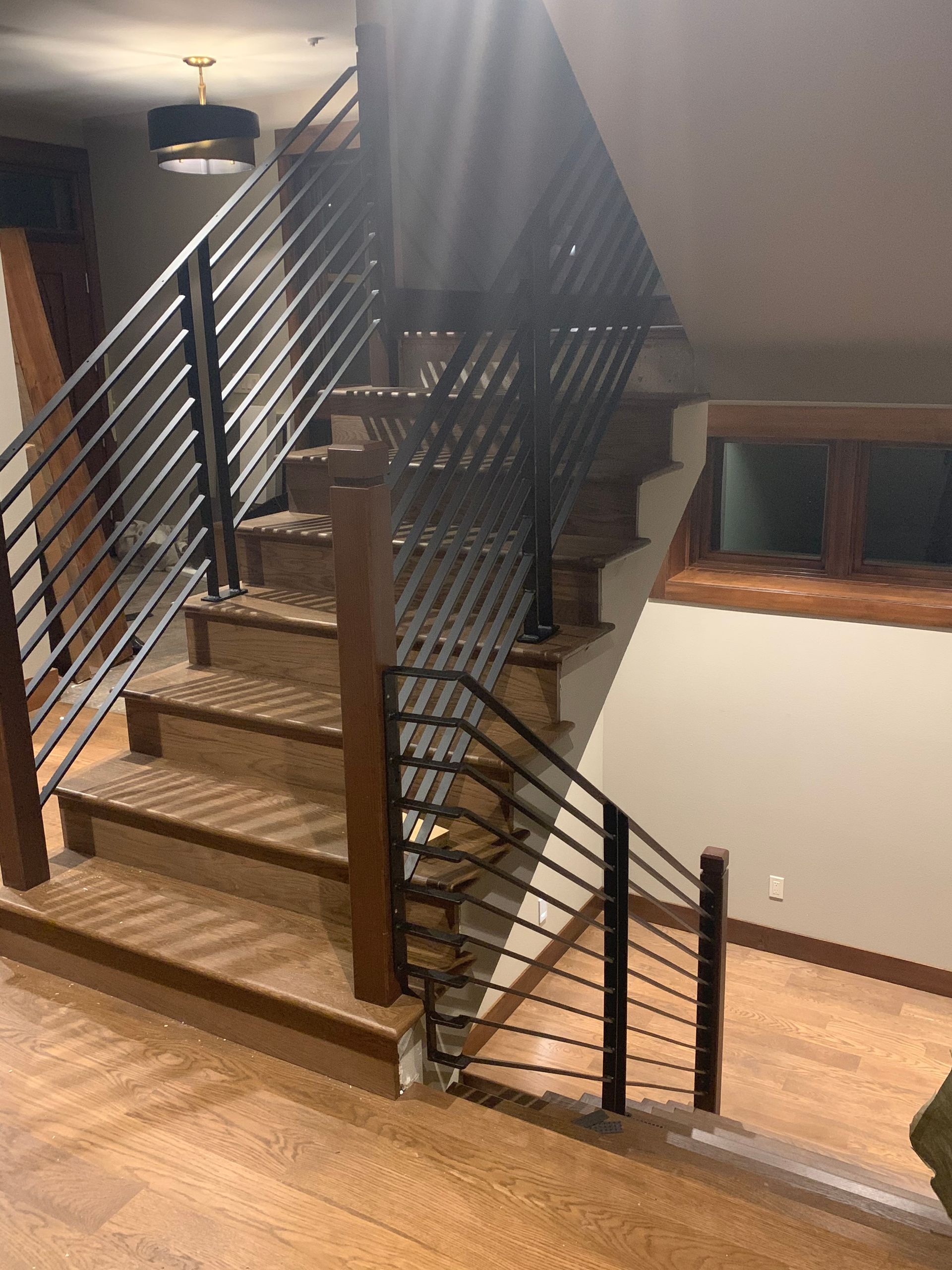 A staircase with a metal railing and wooden steps in a house
