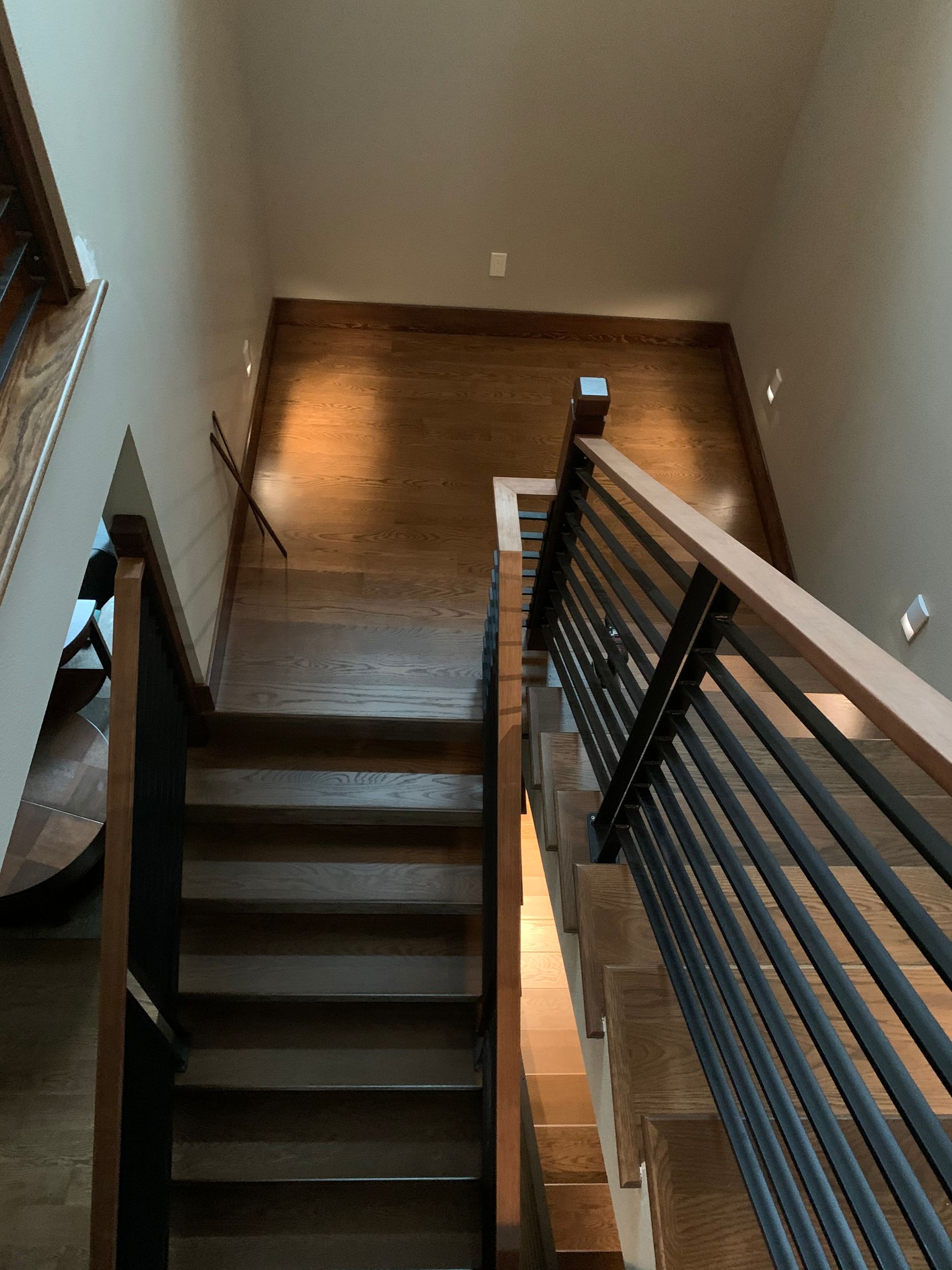 The stairs are made of wood and metal and have a metal railing