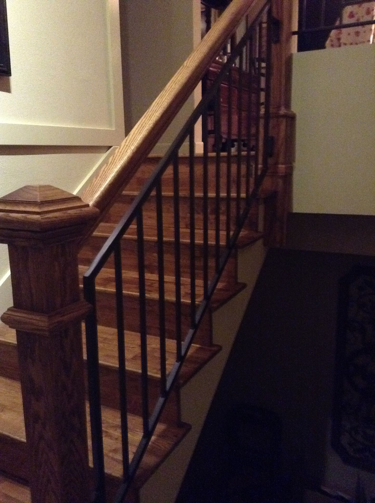 A wooden staircase with a black metal railing