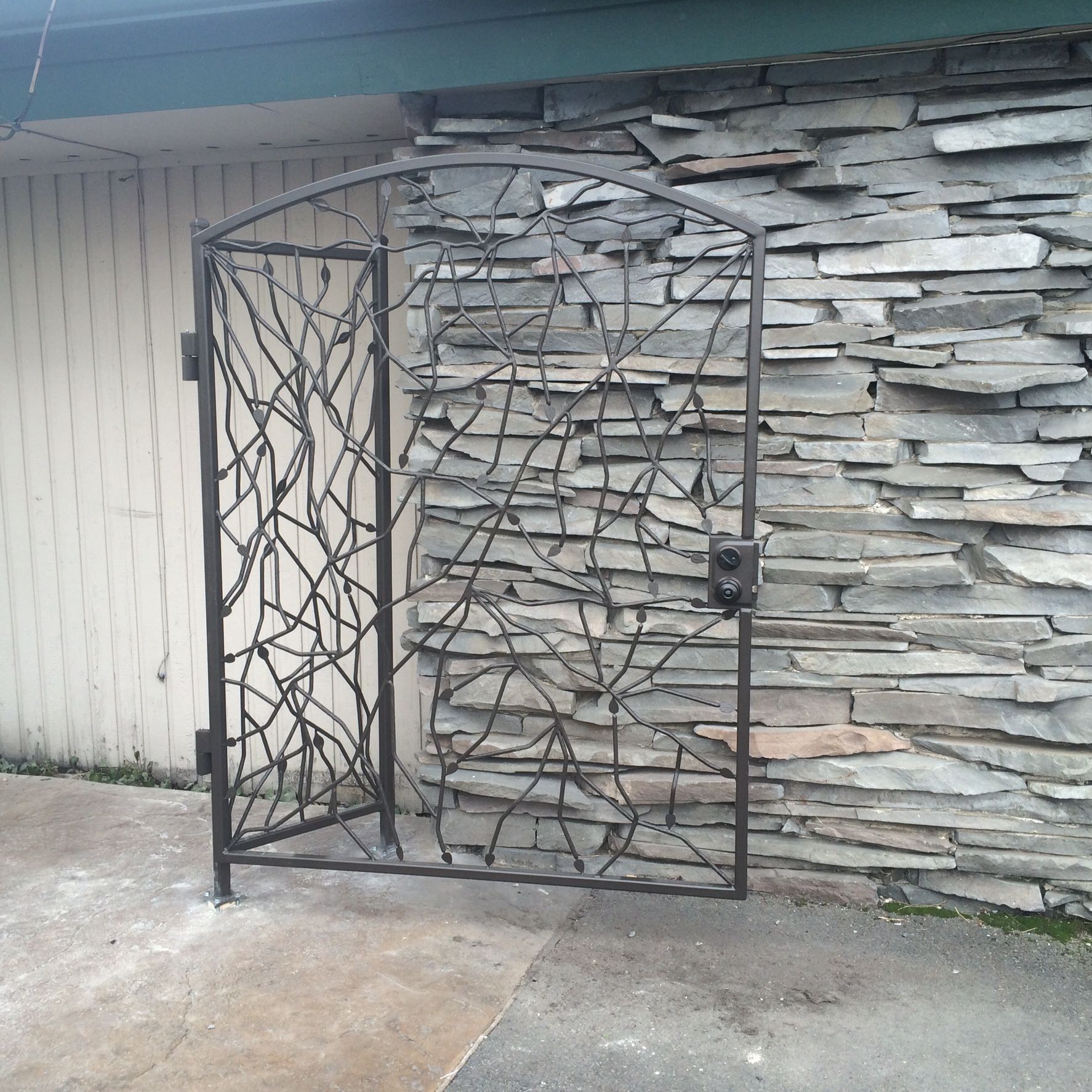A wrought iron gate in front of a stone wall