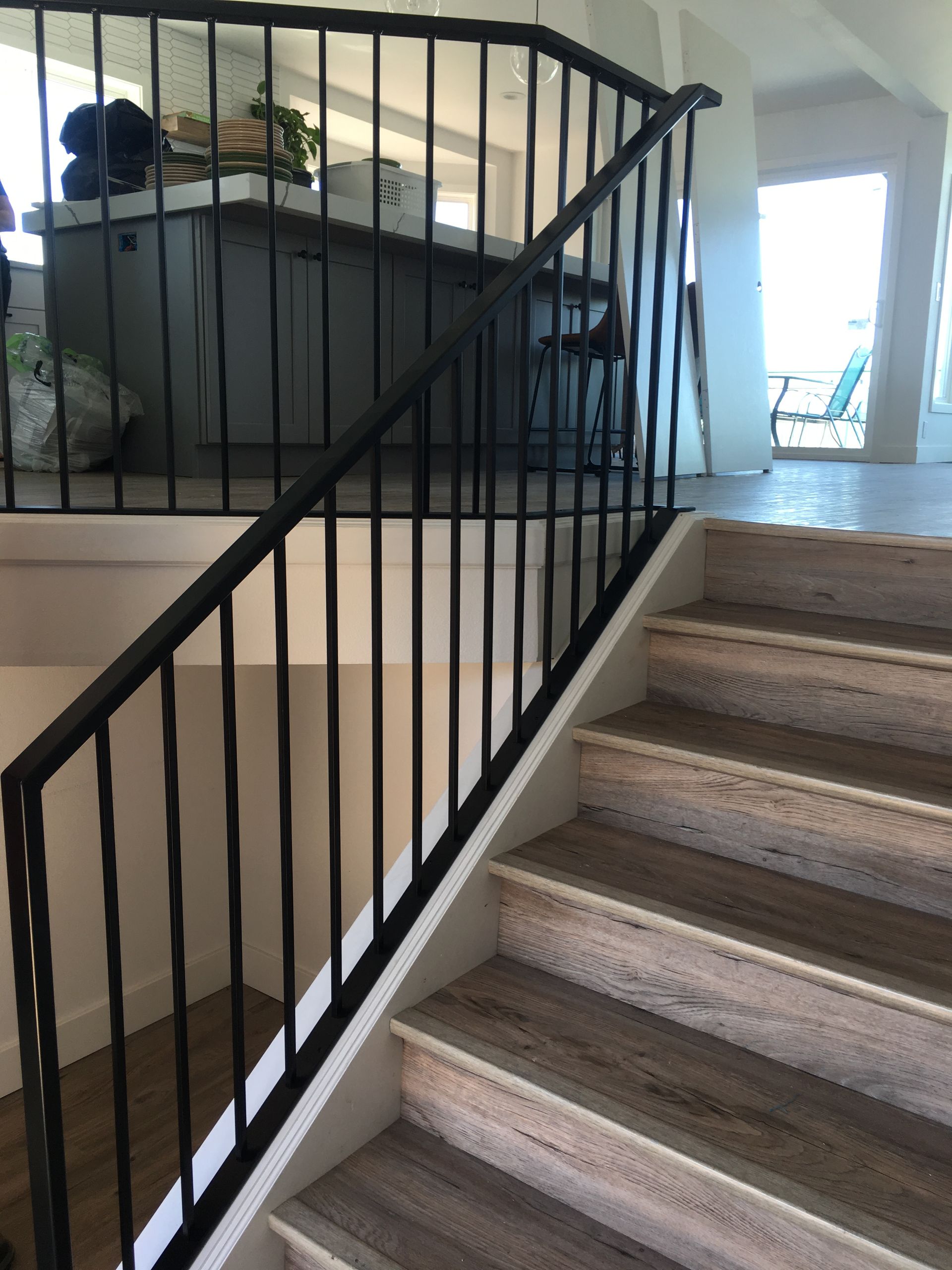 A staircase with a black railing and wooden steps