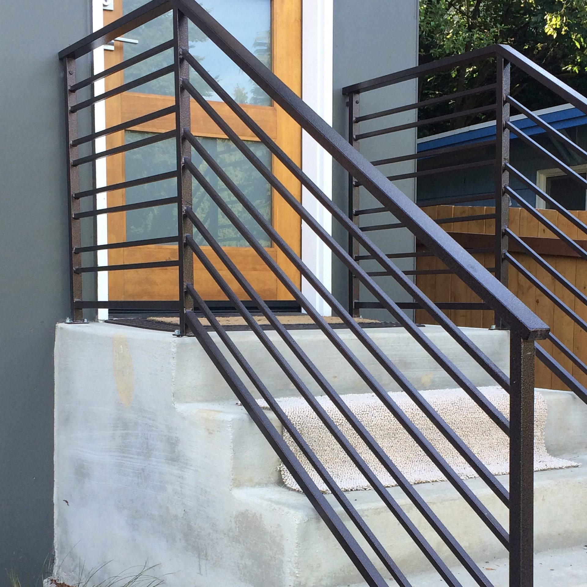 A staircase with a metal railing leading up to a door