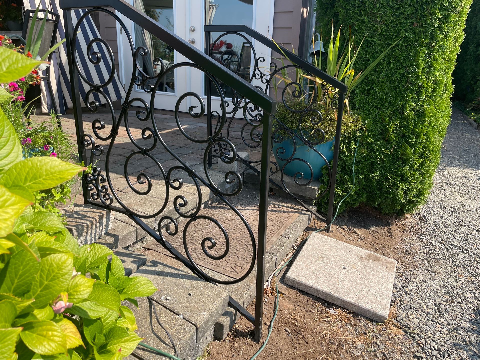 Ornamental iron railing is on the steps of a house