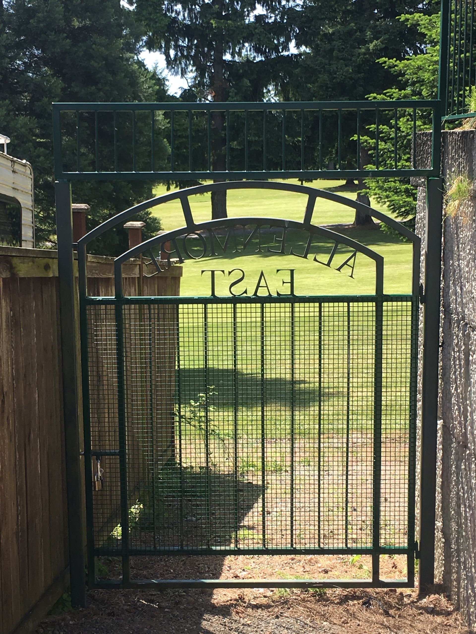 A green gate with the word trail on it