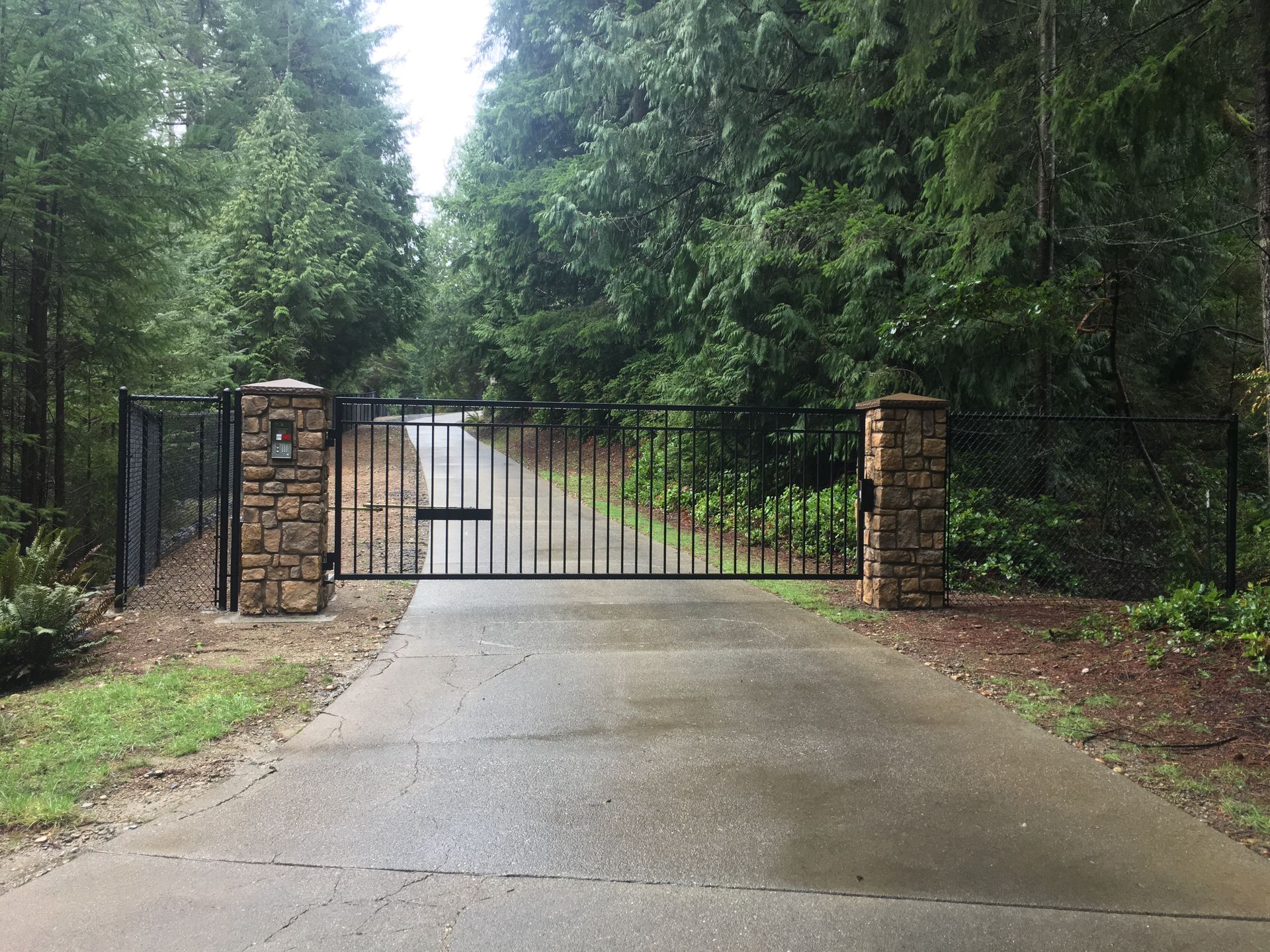 A black fence is surrounding a building with a red sign on it