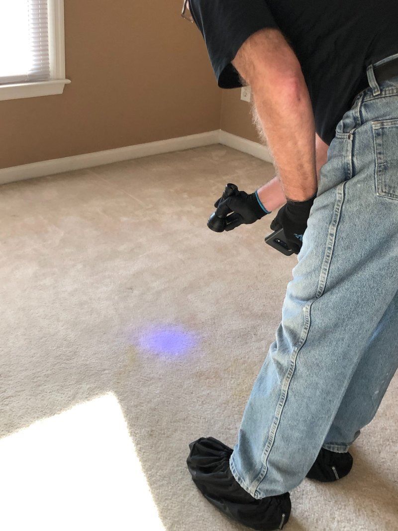 A man is standing in a room with a blue light on the floor.