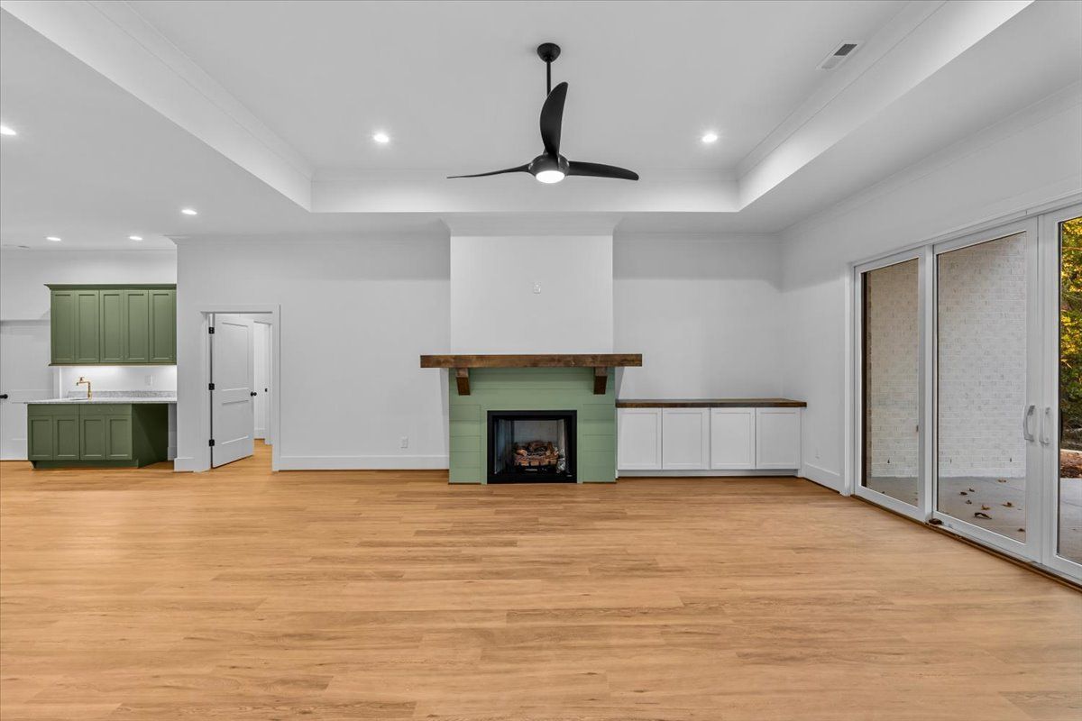 Spacious, modern living room with hardwood floors, fireplace, and green accents.
