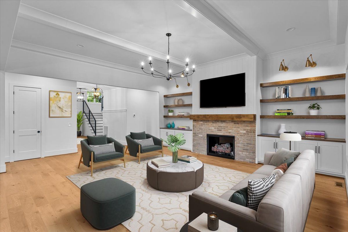 Living room with fireplace, TV, built-in shelves, hardwood floors, and modern furniture.