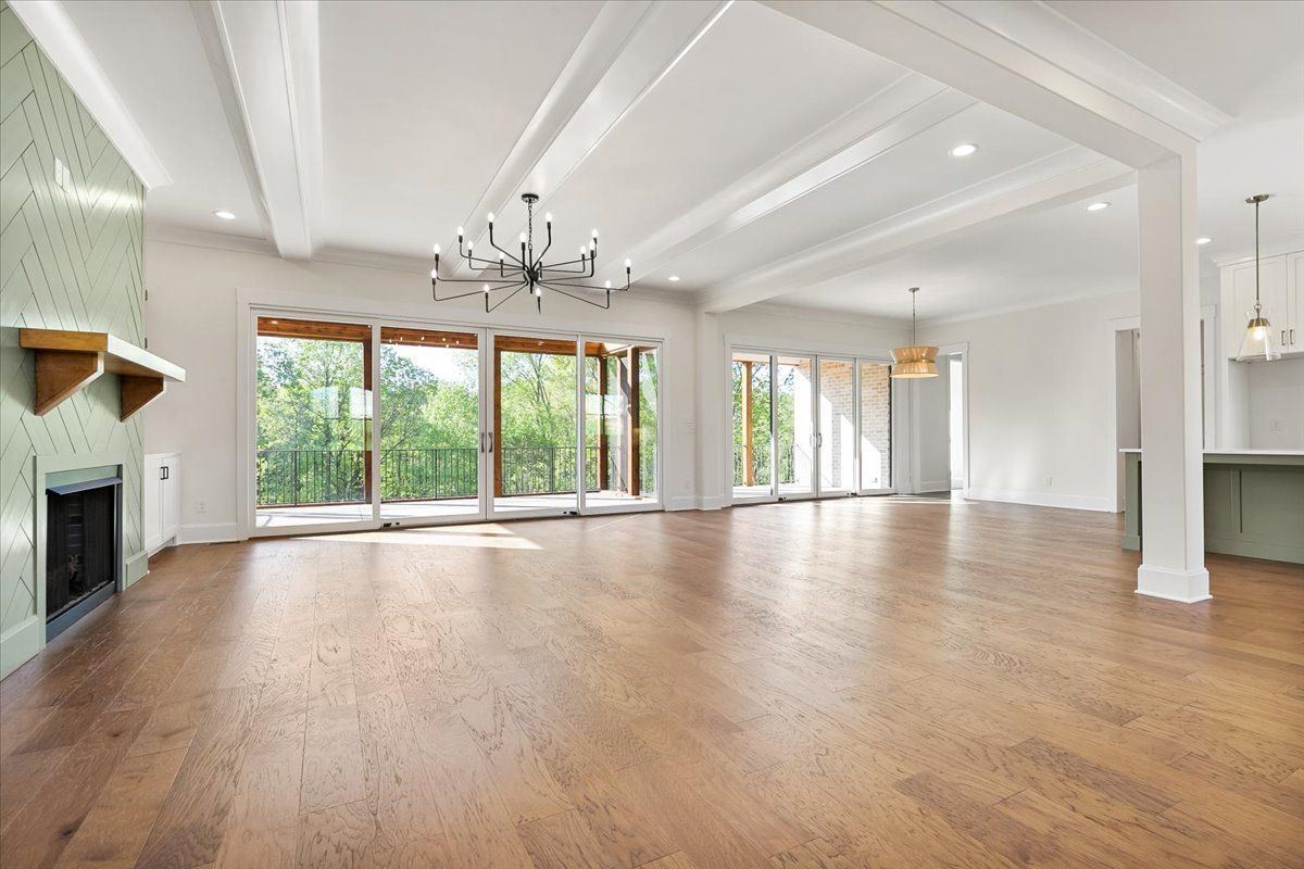 An empty living room with hardwood floors and a fireplace