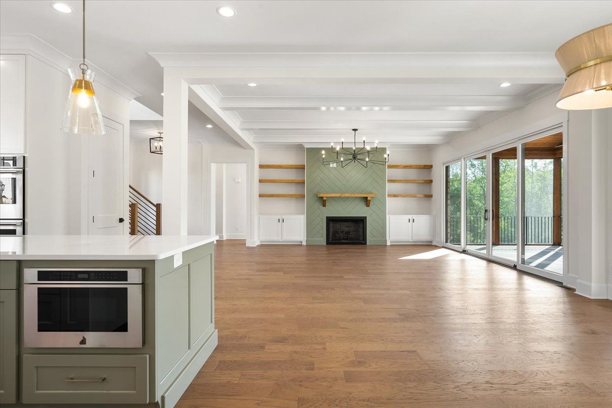 A large empty kitchen with hardwood floors and a fireplace