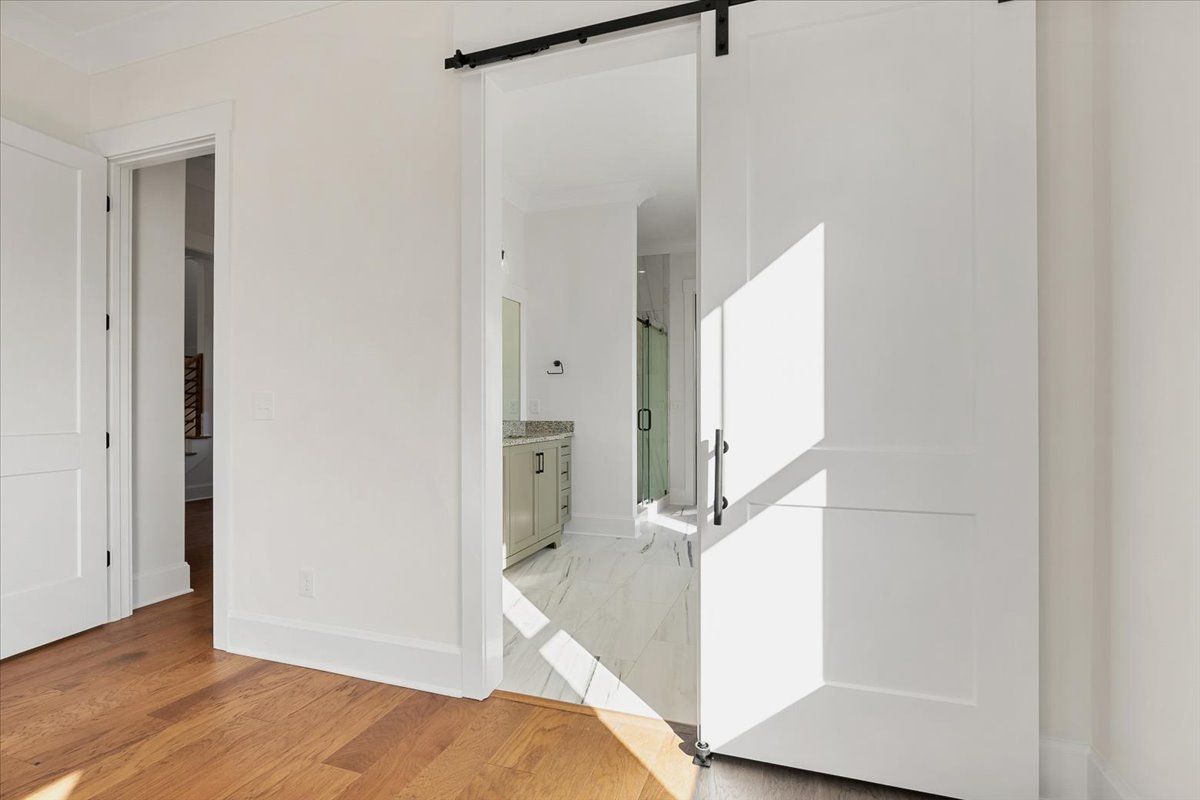 Room with a sliding barn door leading to a bathroom