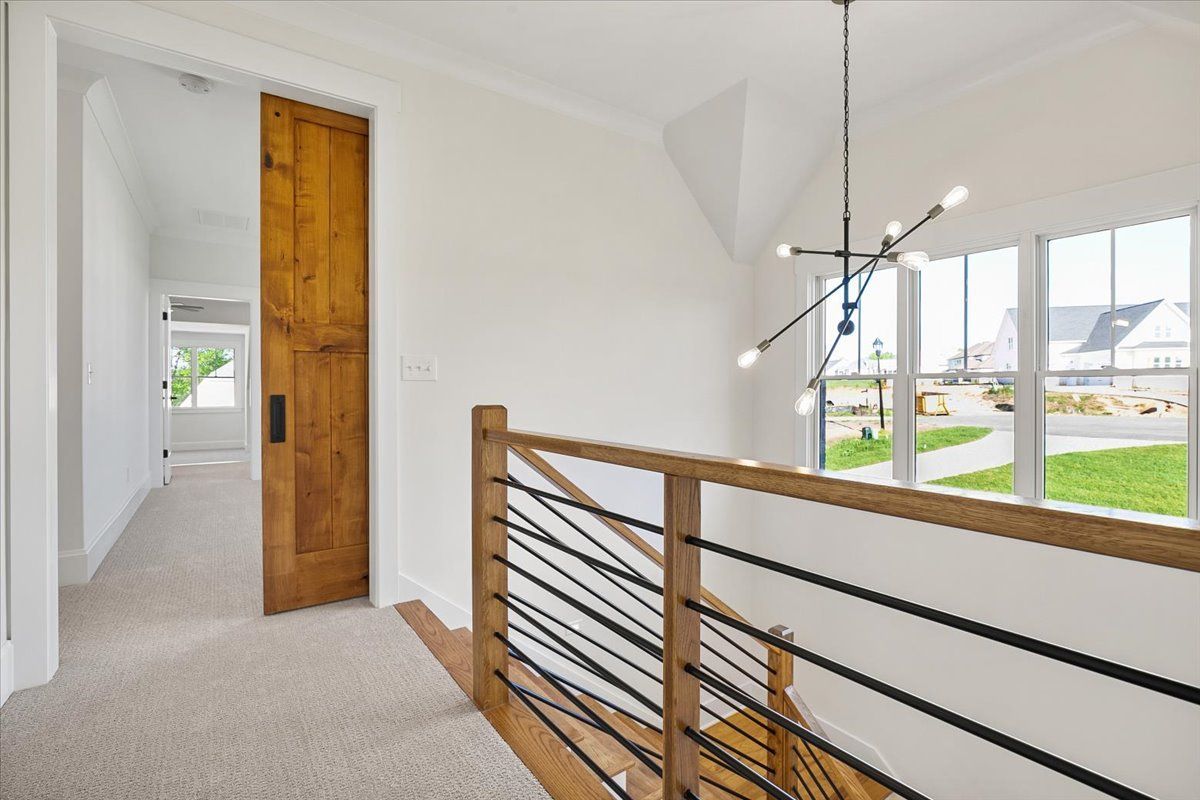 A hallway with a wooden door and stairs in a house