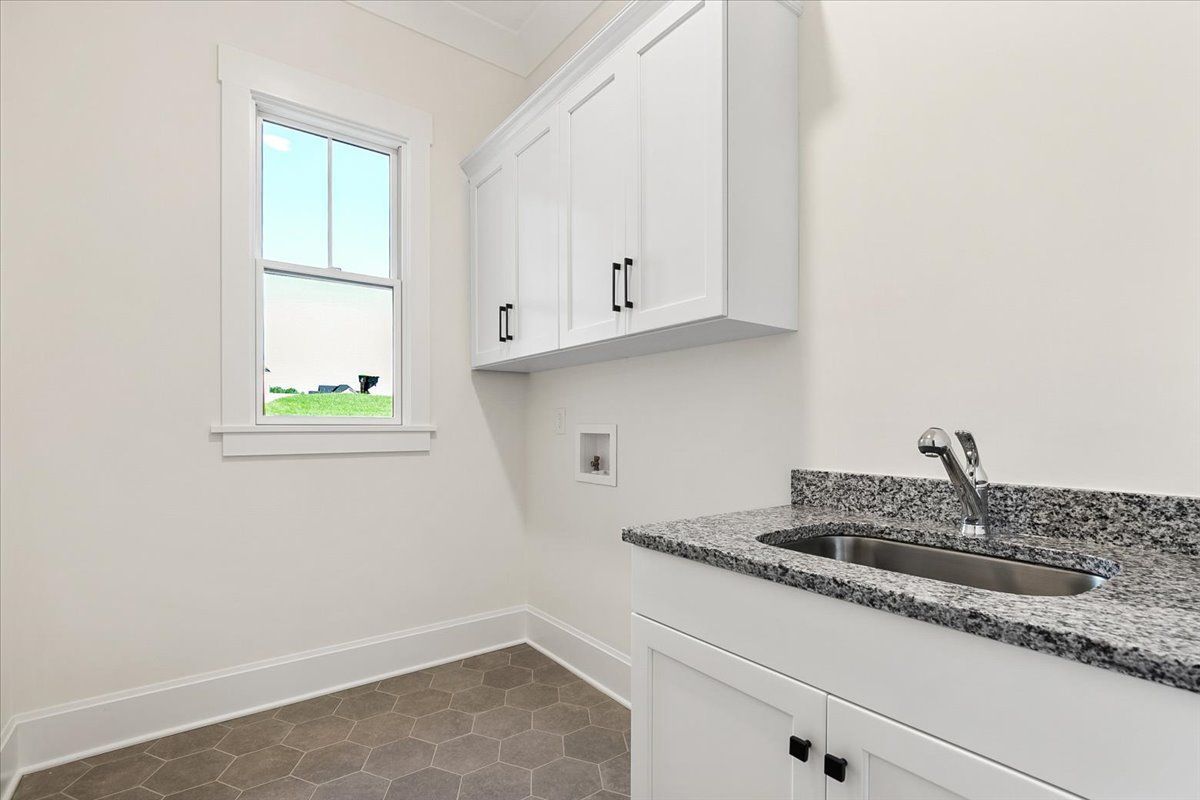 Room with white cabinets and sink