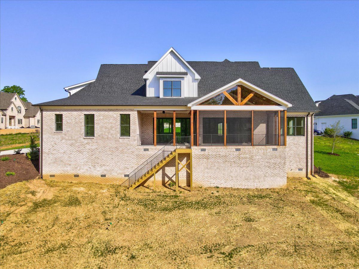 The back of a house with a screened-in porch and stairs