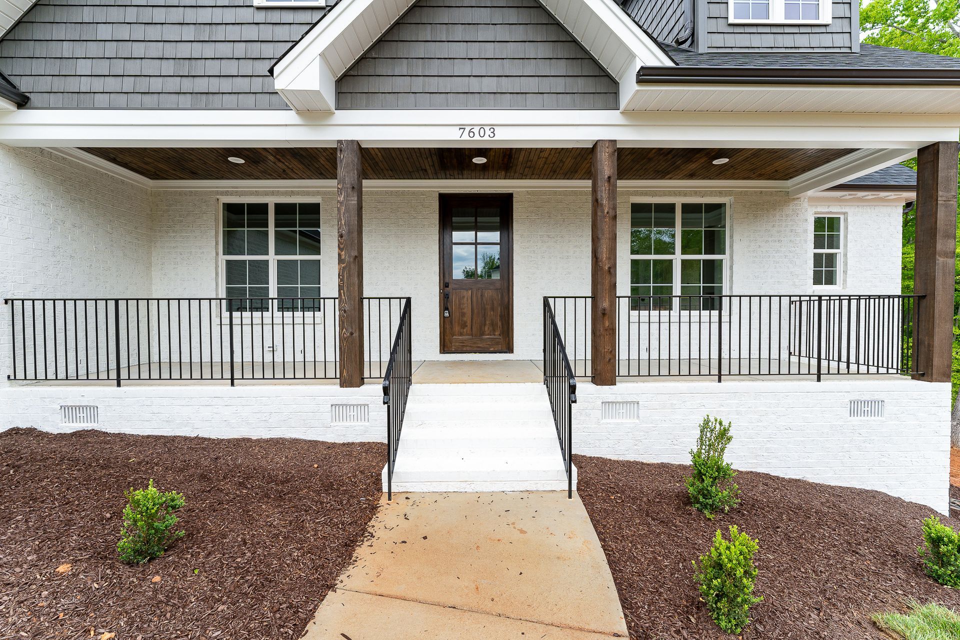 A white house with a porch and stairs leading up to it