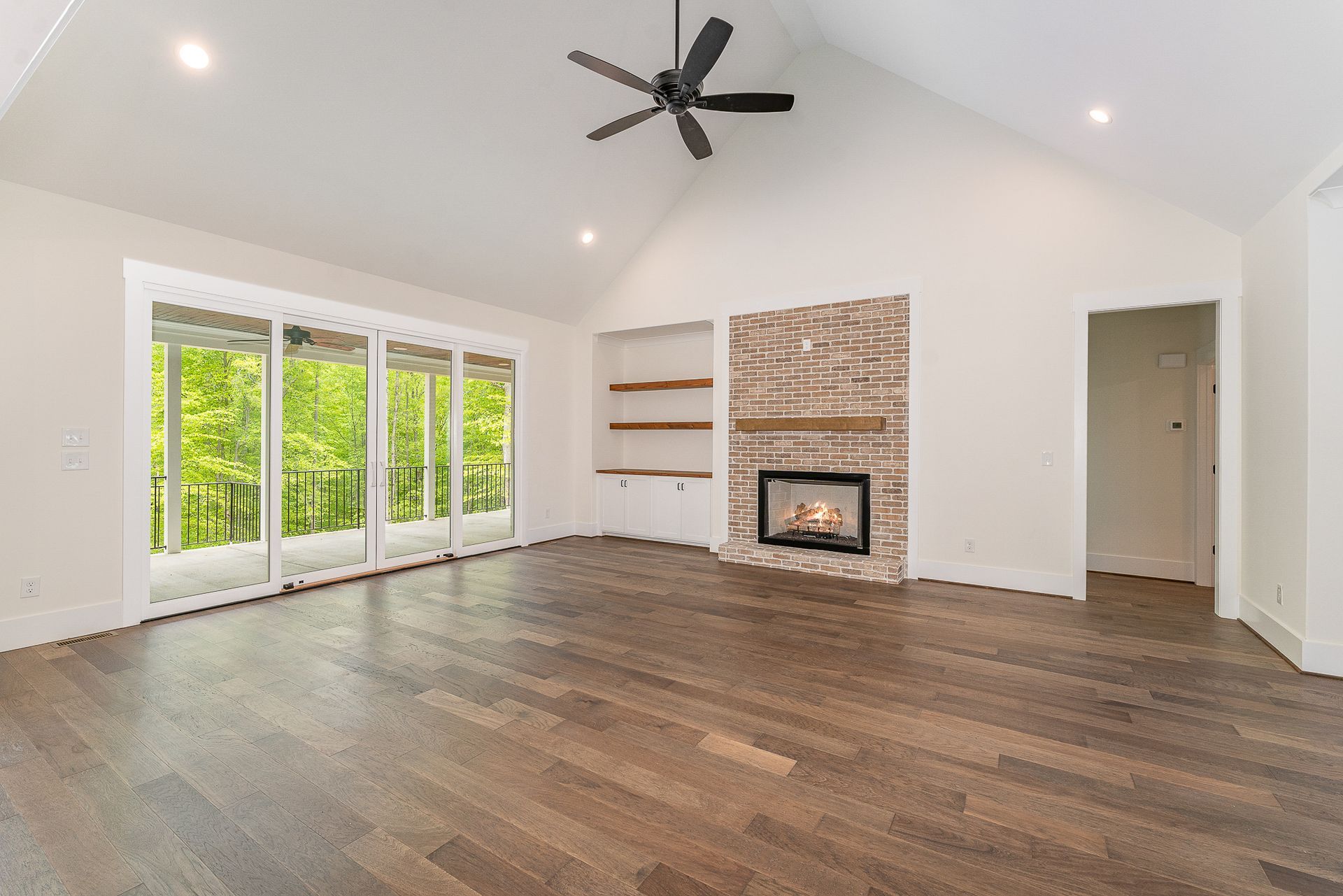 An empty living room with hardwood floors and a fireplace
