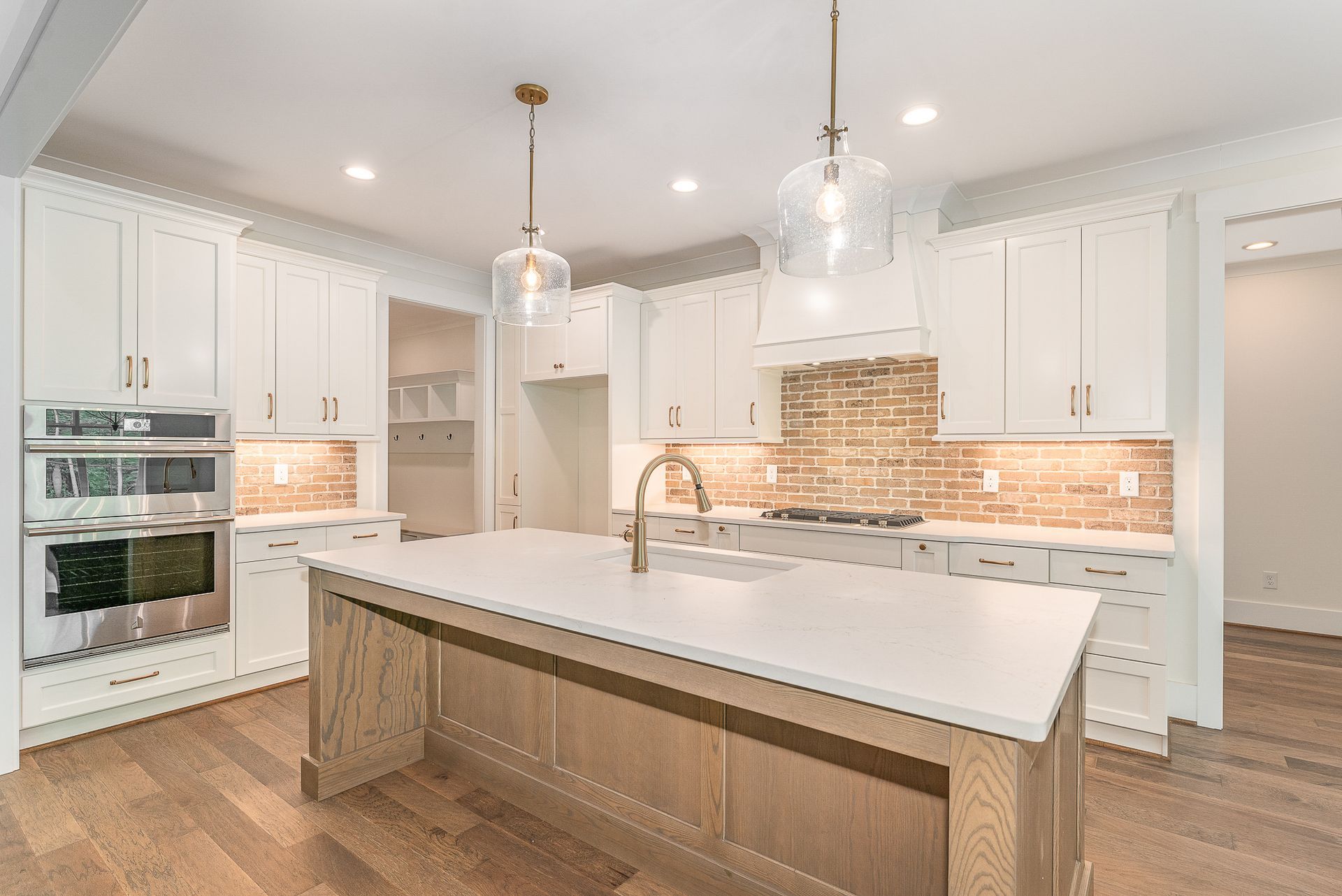 A kitchen with white cabinets and a large island in the middle