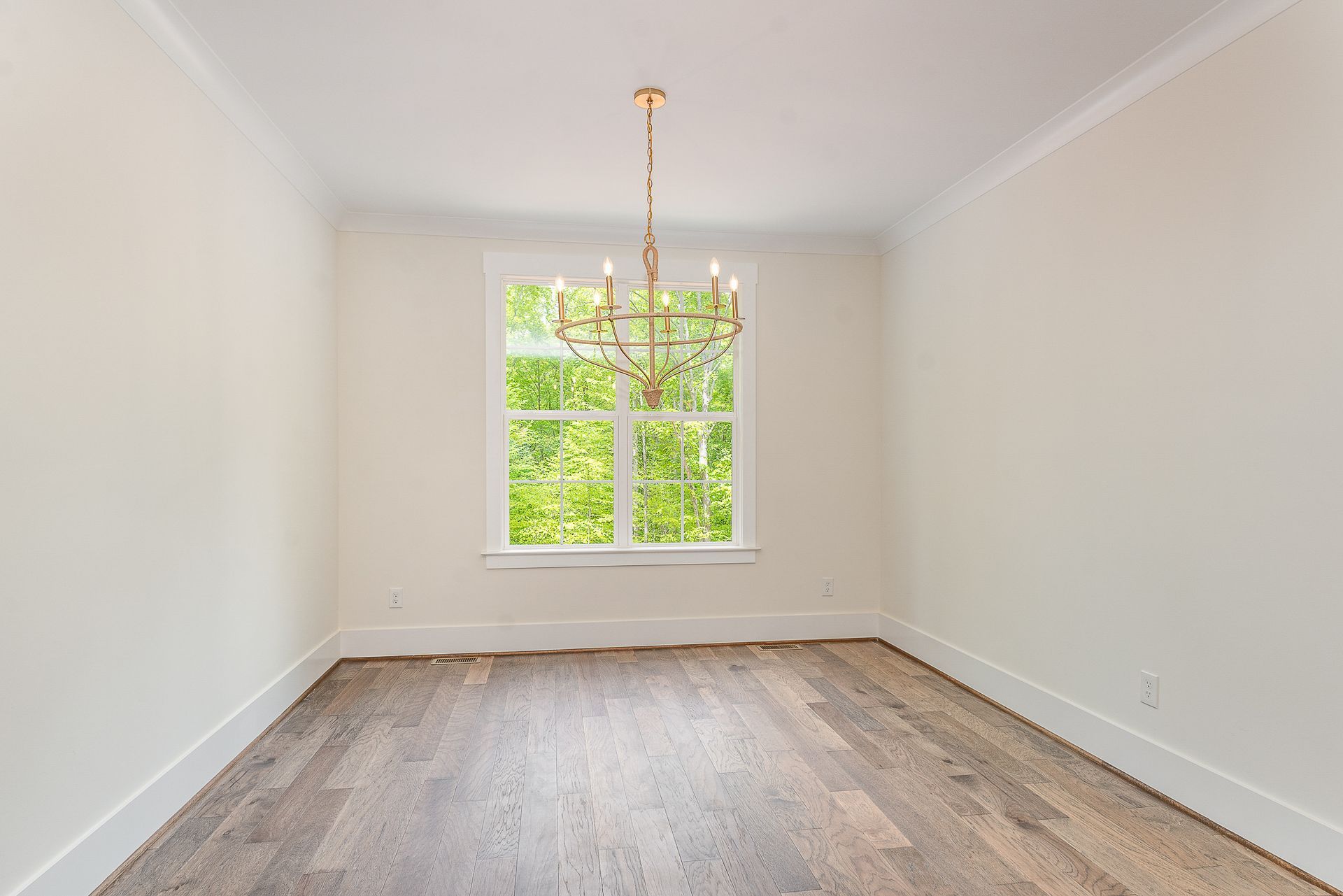 An empty room with a chandelier and a window