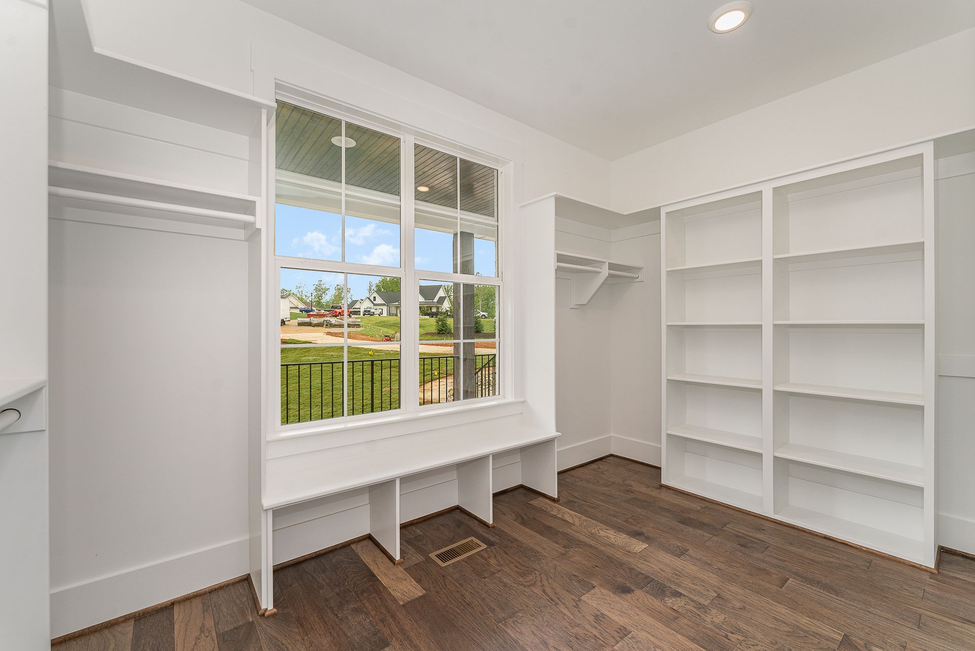A walk-in closet with empty shelves and a window