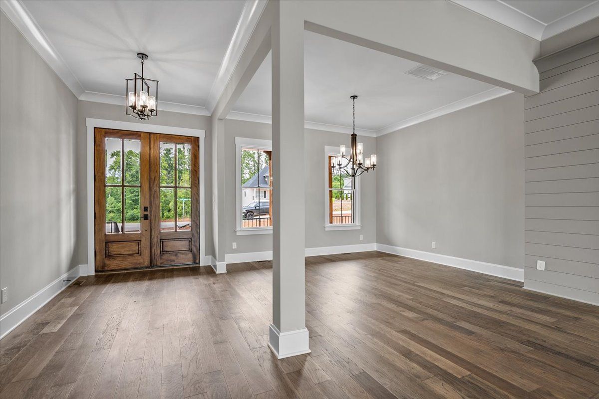 An empty room with hardwood floors and a pillar